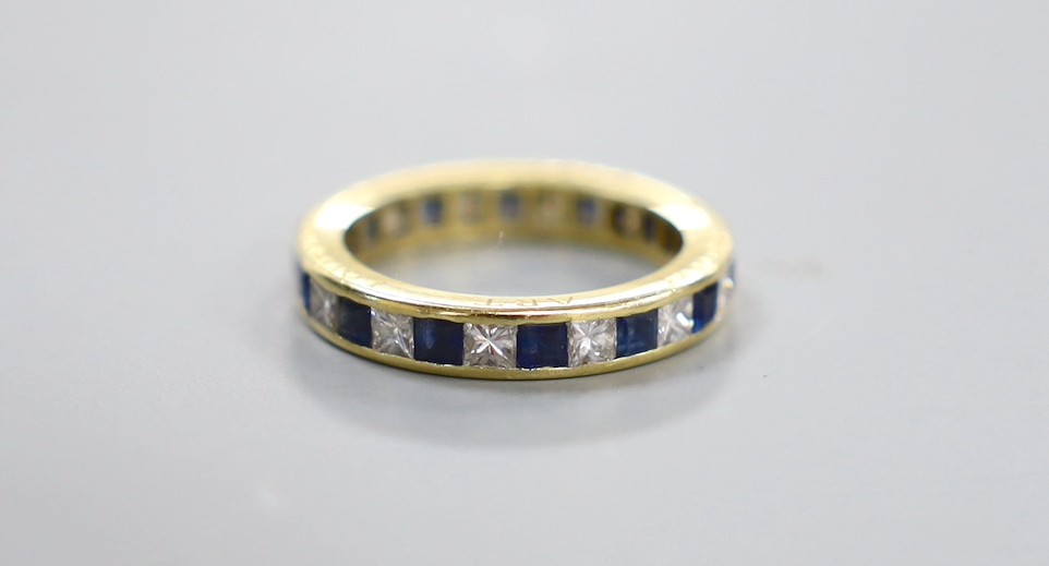 A yellow metal, sapphire and diamond set full eternity ring, the side of the shank engraved 'Thou Art Lovely And True', size N, gross weight 4.5 grams.